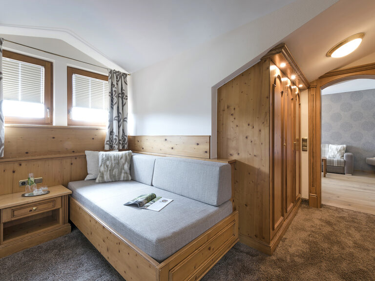 Gemütlicher Wohnbereich mit Sitznische und Magazin in der Silberbergsuite des Wellnesshotels Mooshof in Bayern.