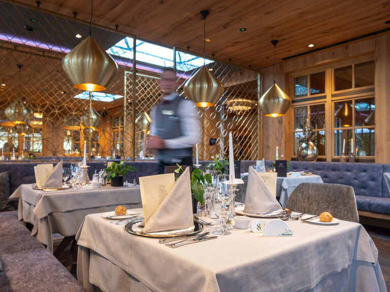 Ein eleganter Tisch mit weißem Tischtuch im Restaurant Mooshof.