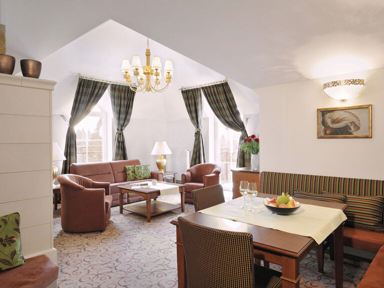 Großes Wohnzimmer mit Ledercouch und edlen Kirschholzmöbeln in der Traumblick Suite des Wellnesshotels Mooshof im Bayerischen Wald.