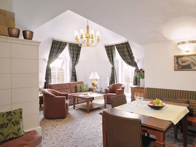 Ein heller Ess- und Wohnbereich mit luxuriösen Kronleuchter in der Traumblick Suite des Wellnesshotels Mooshof in Bodenmais.