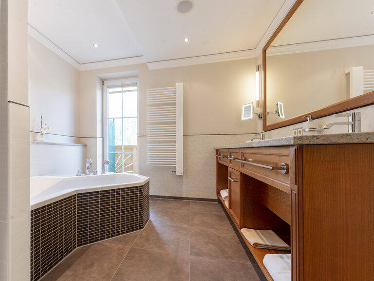Helles Badezimmer in der Turmsuite Hochzell des Wellnesshotels Mooshof im Bayerischen Wald mit moderner Sanitärtechnik und großer Badewanne.