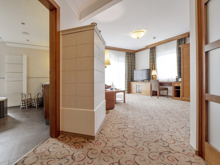 Die hochwertige Einrichtung mit modernen Badezimmer und Fernseher in der Turmsuite Hochzell des Wellnesshotels Mooshof in Bayern spiegelt erstklassiges Design wider.