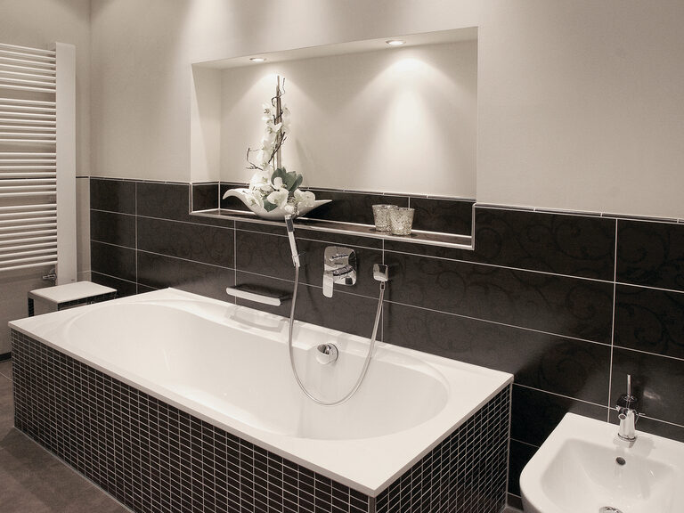 Luxuriöse weiße Badewanne mit edlen schwarzen Fliesen in der Turmsuite Kronberg des Wellnesshotels Mooshof im Bayerischen Wald.