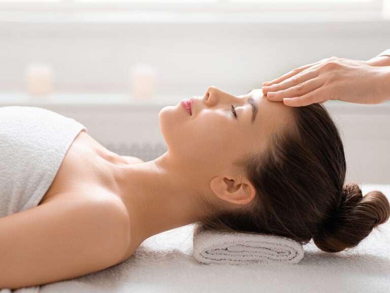 Eine Frau genießt eine entspannende Gesichtsmassage in dem luxuriösen Spa des Wellnesshotels Mooshof in Bodenmais.