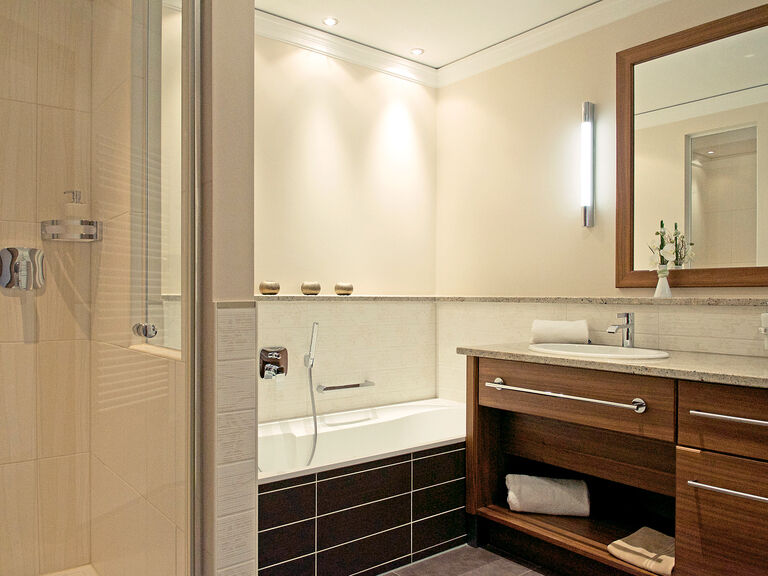 Einladende Badarmatur in der Gartensuite mit geräumiger Dusche und Badewanne im Wellnesshotel Mooshof in Bodenmais.