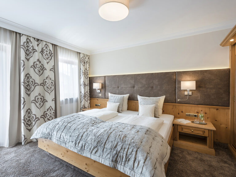 Helles Zimmer Typ 12 mit einem großzügigen Bett und Zugang zum Nordbalkon im Wellnesshotel Mooshof in Bodenmais..