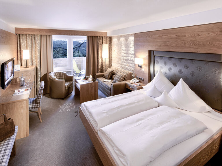 Modernes Zimmer Typ 9 im Hotel Mooshof in Bodenmais mit komfortablen Doppelbett und Fernseher zur Unterhaltung.