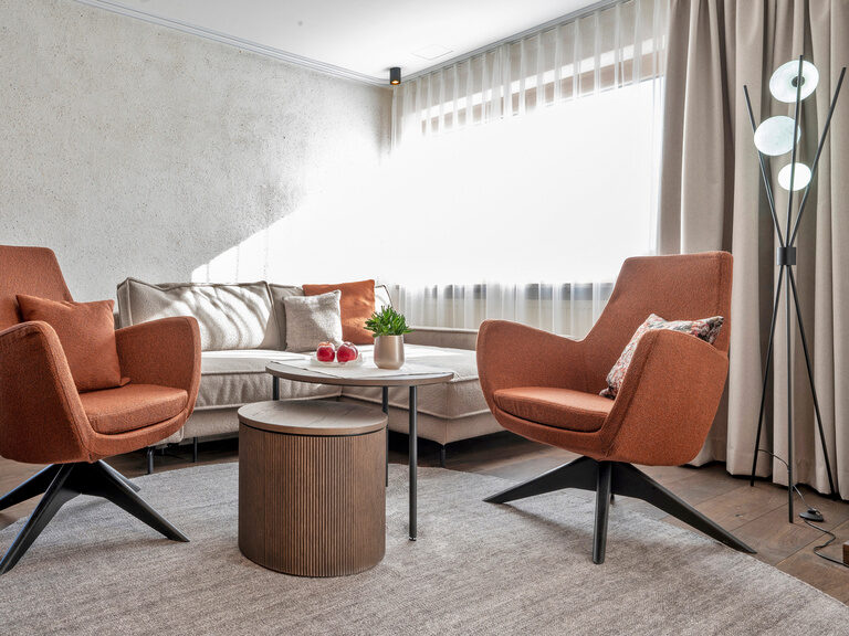 Gemütlicher Sitzbereich im Zimmer Typ 3A des Wellnesshotels Mooshof in Bayern mit zwei Sesseln und einem Couchtisch.