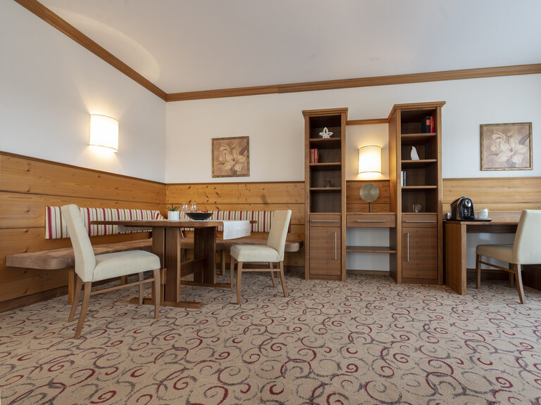 Die Erkersuite Deluxe mit großzügigem Wohnraum und gemütlicher Eckbank im Wellnesshotel Mooshof im Bayerischen Wald.